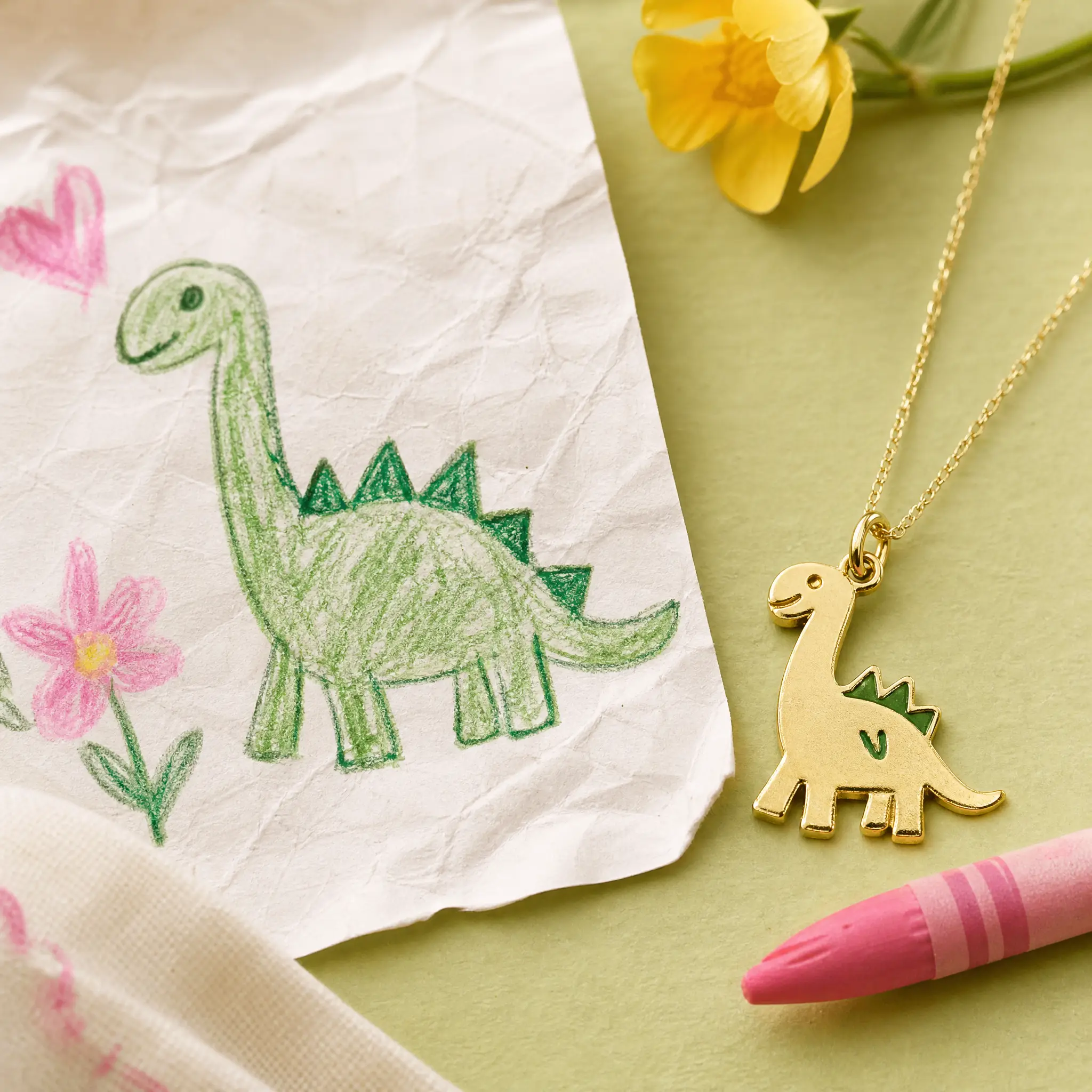 A child's dinosaur drawing and matching jewellery concept